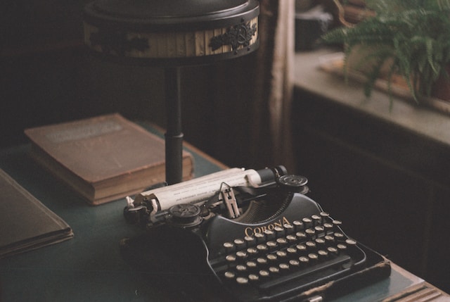 Mașină de scris veche, așezată pe o masă.