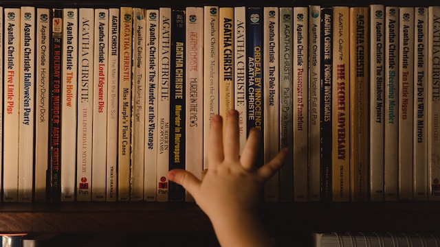 O mână care se întinde după cărți de Agatha Christie